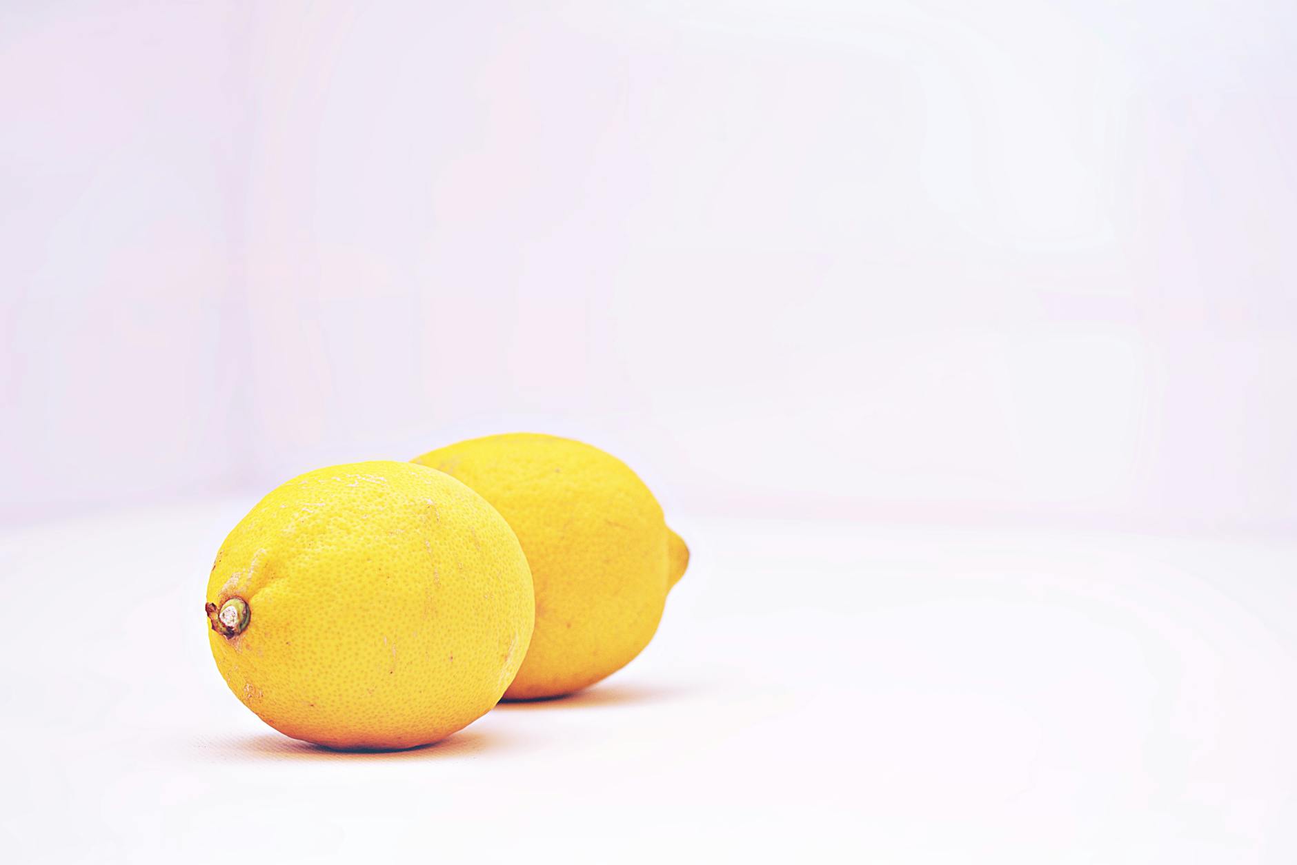 Two bright lemons on a white background, symbolizing fresh starts and renewed sensation