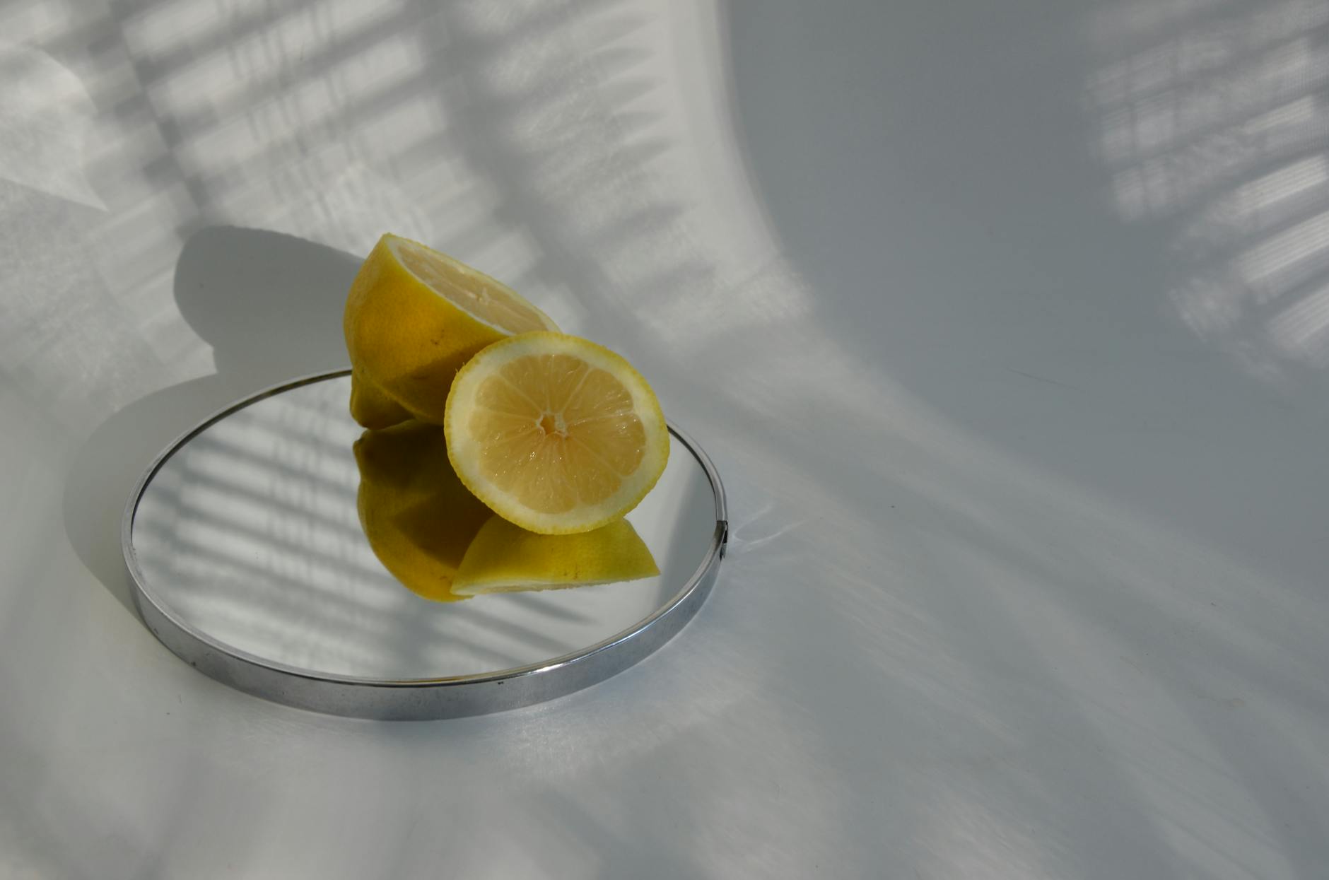Sliced lemons on a mirror with soft shadows, representing delicate and sensitive anatomy