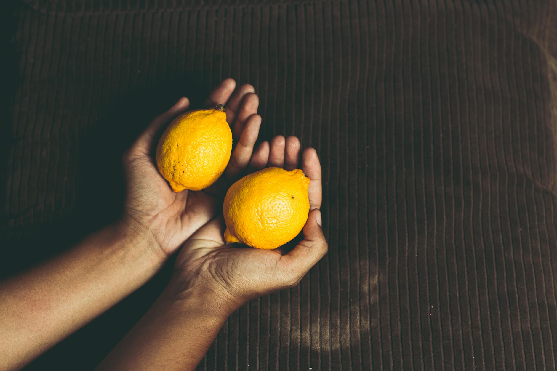 Woman smiling and enjoying fresh citrus, representing joy and self-care