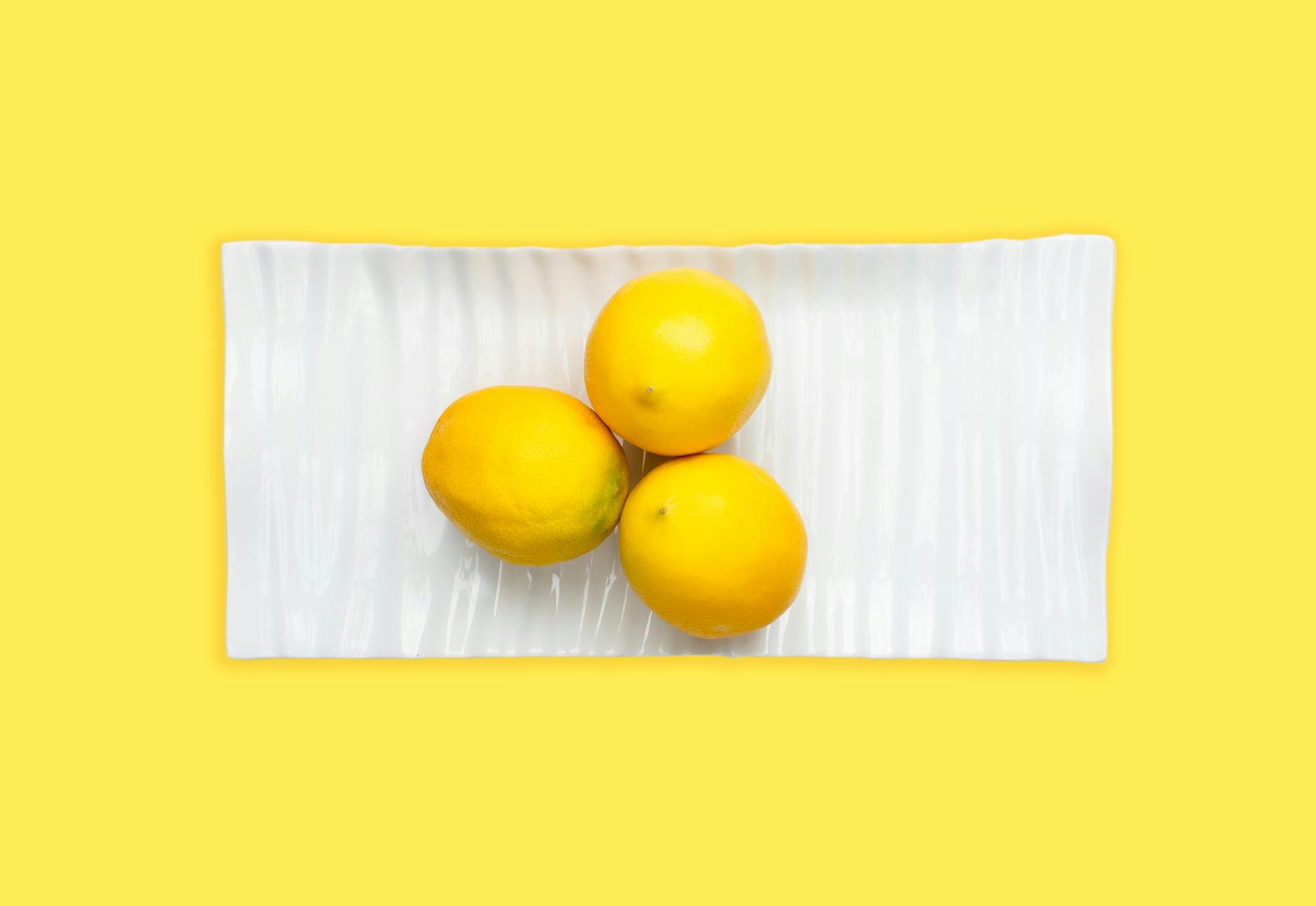 Fresh lemons on a white plate symbolizing openness and natural communication about pleasure