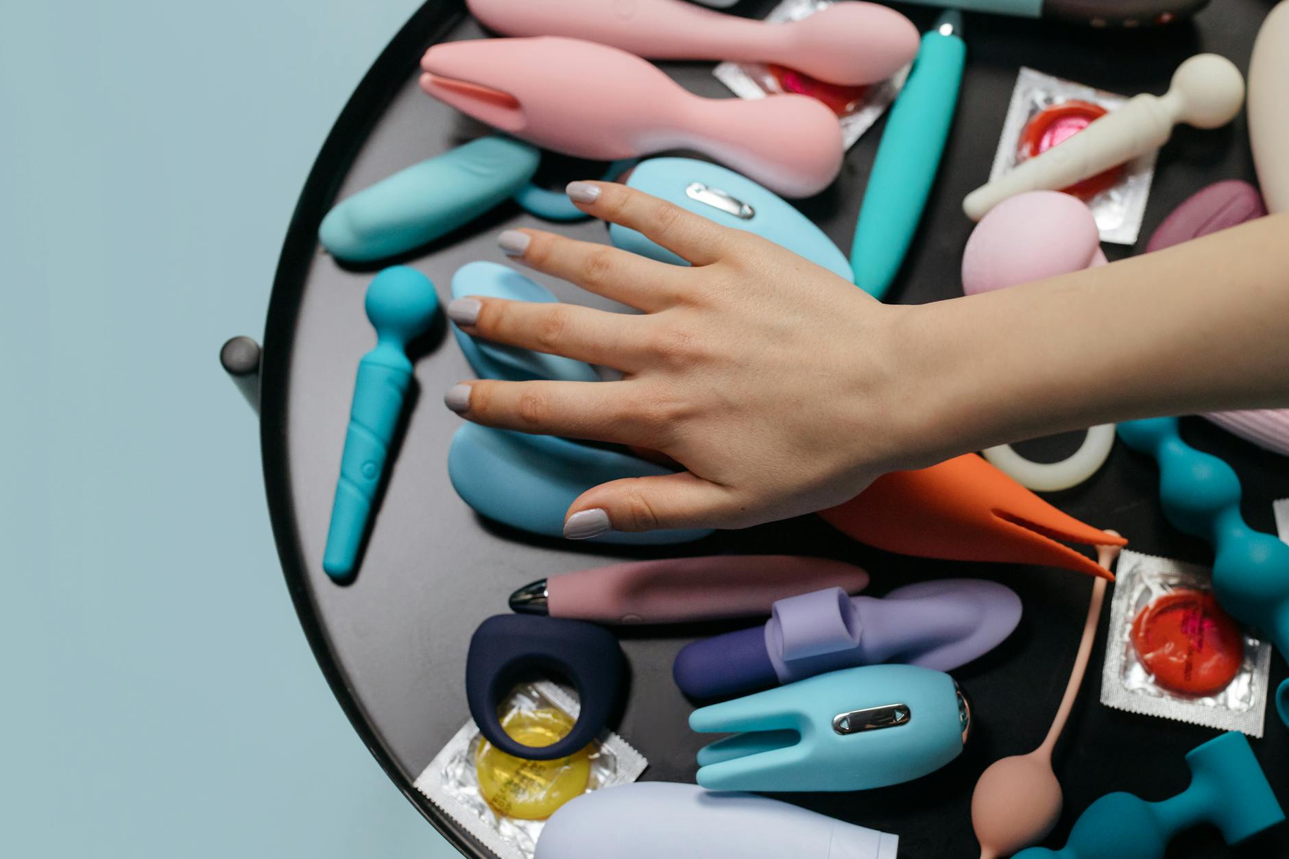 Three colorful vibrators arranged on white fabric, highlighting their smooth texture