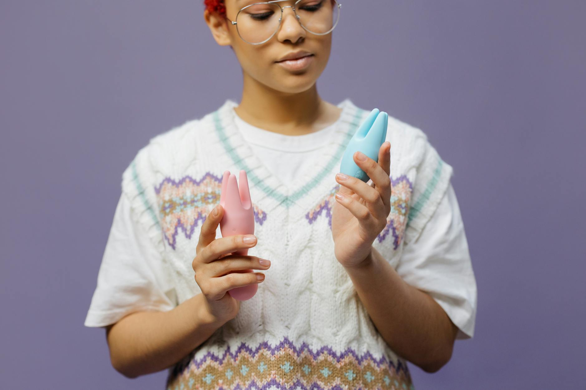 Woman holding a blue silicone vibrator in contemplative pose