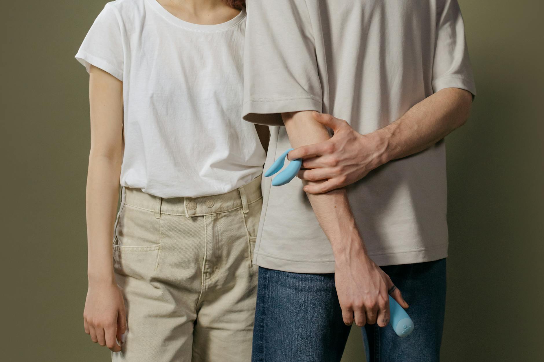 A couple standing close together, exploring intimacy with a modern vibrator