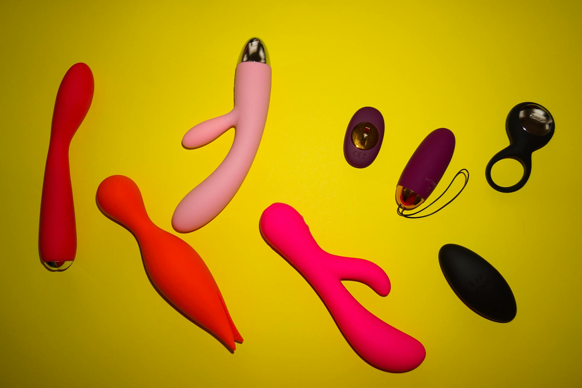 Hands holding a blue clitoral vibrator against a soft purple background